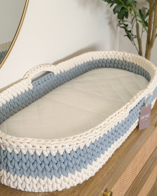Blue and white woven basket with a tag on a wooden surface
